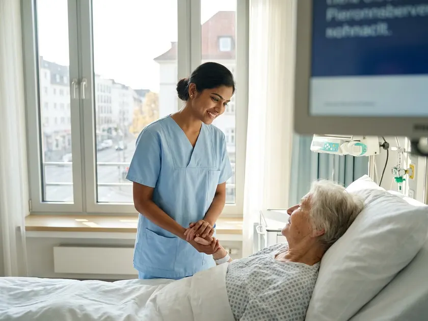 Indian nurse caring for a patient in a German hospital